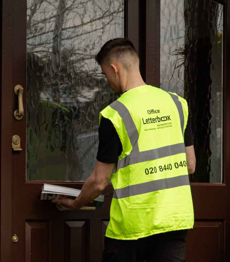 A man is delivering some items through a letterbox
